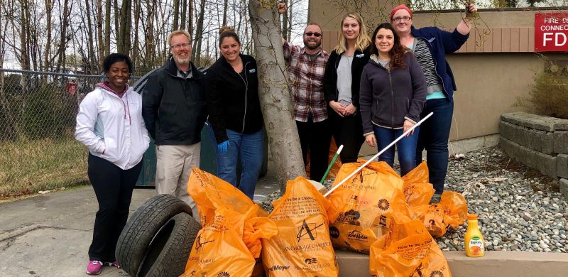 The Consumer Direct Care Network Anchorage staff posing with the orange bags of trash they picked up at the 2019 Anchorage Citywide Cleanup